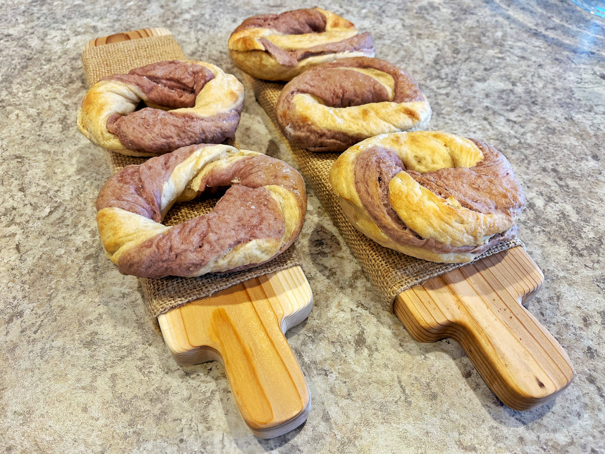 Wrinkly overproofed bagels resting on bagel boards