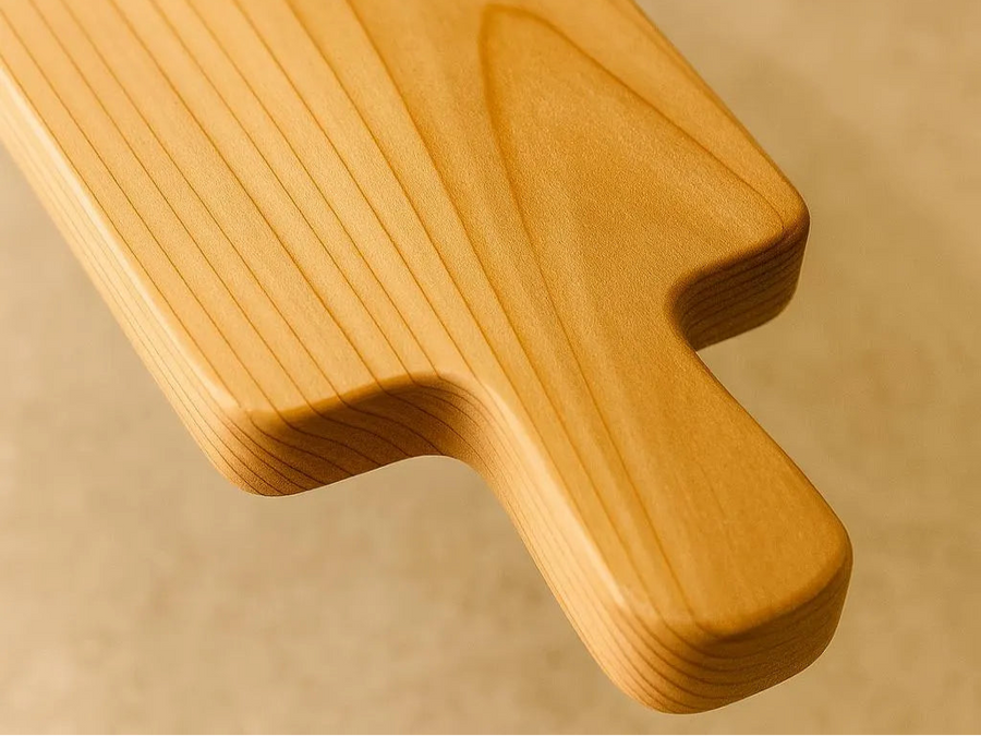 Closeup shot of cedar bagel board handle exposing grain and quality cuts.