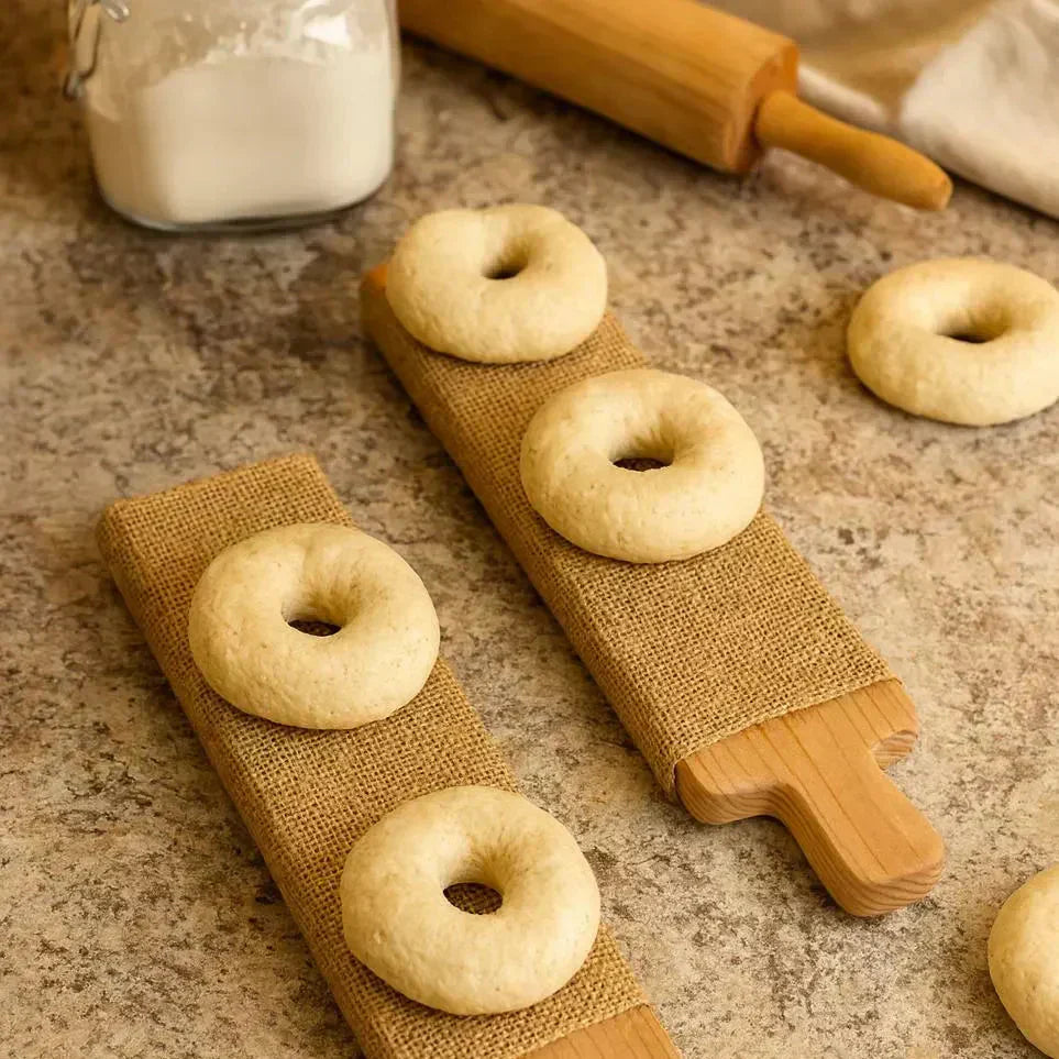 Bagel boards on countertop with raw bagels and ingredients. 