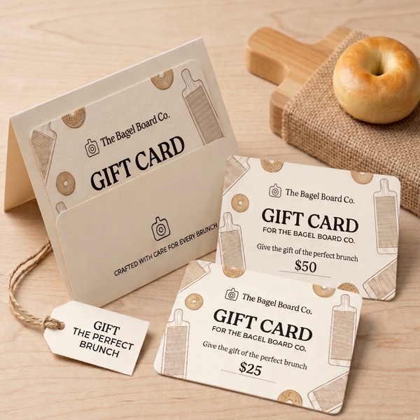 The bagel board company gift cards in front of a bagel board with a bagel on top.